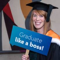 graduating student smiling with cap and gown