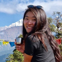 Trek to Teach-er , Reese, posing with tea by the mountains