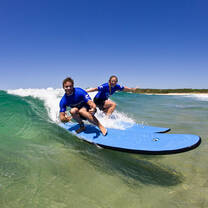 two people surfing on one board