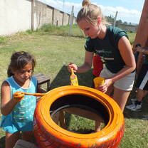 A volunteer and child painting during a community day