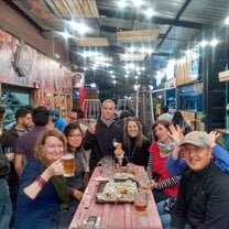 people sitting around a table in a restaurant eating