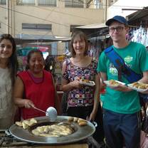 people standing around a large pot cooking together