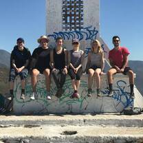 group smiling sitting on the edge of a stone fountain