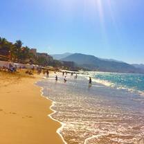 sun shining down on beach with blue waters