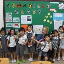 group of children in uniforms in front of board