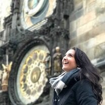 Girl standing by astronomical clock in Prague Old Town