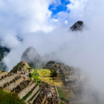 Machu Pichu in the clouds on a sunny day.