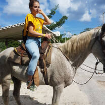 student riding a horse on optional excursion