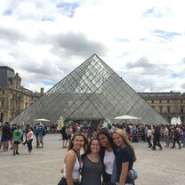 students in front of glass pyramid at the Louvre
