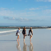 students walking along white beaches in the Galapagos