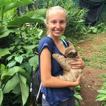 student holding a baby sloth