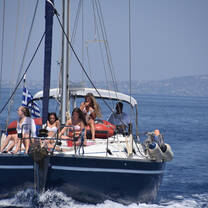 student sitting on bow of sailboat