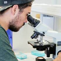 Male uses a microscope 