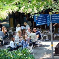 UEA students in square sitting at tables eating