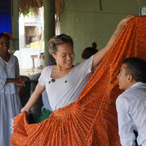 A volunteer and a local dance teacher dancing a traditional dance style