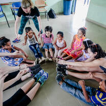 Volunteers and local youth sitting in a circle together