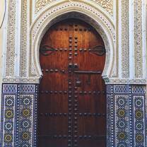An antique arched doorway with mosaics around the outside