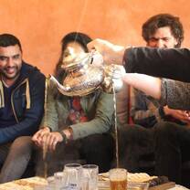 Students pour tea at a henna party