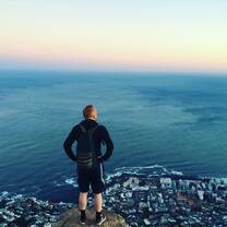 person on cliff looking over ocean