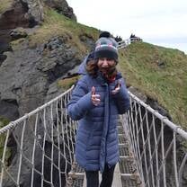 person in large jacket on bridge