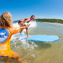 instructor helping someone surf
