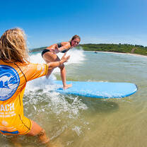 instructor helping someone surf