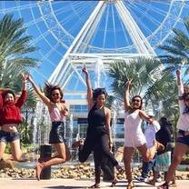 People jumping up in the air in front of amusement park