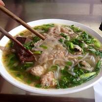 soup in bowl with noodles and vegetables and chopsticks