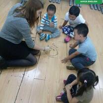 teacher with students on classroom floor drawing