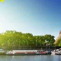 Eiffel tower with blue skies and green trees with canal  
