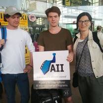 group of students at airport holding sign