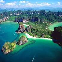 view from above an island with dark blue water and green mountains