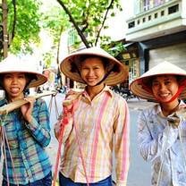 three people wearing traditional vietnamese hats