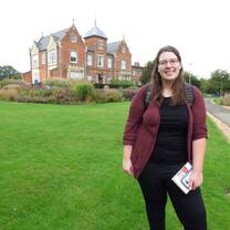 student smiling in front of Reading campus 