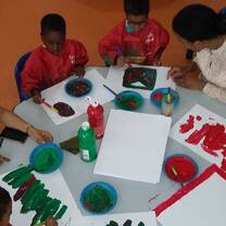Women helping children do artwork.