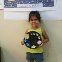 little girl showing her solar system art made
