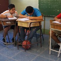 young boys inside the classroom writing