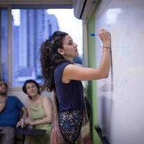 A woman writing on the whiteboard.