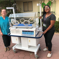 an incubator in the middle of two women