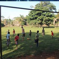 group of children playing soccer on a greeny field