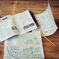 a magazine, a sketch and a pencil on the floor 