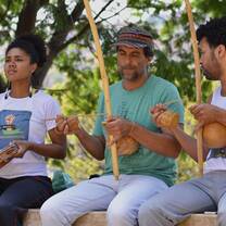 Student and community partners playing music for capoeira