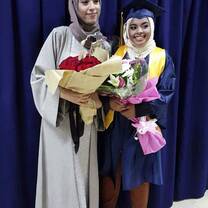 Two ladies holding a flower