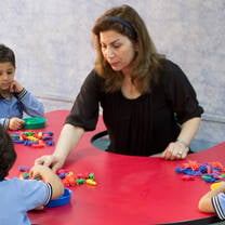The girl and kids plays a blocks
