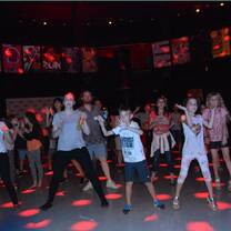 men, women, and children dancing in a dim light