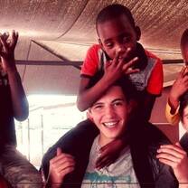 three young men carrying 3 little boys on their shoulders