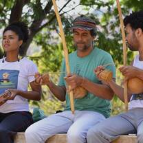 Student and community partners playing music for capoeira