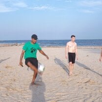 guys playing soccer on the beach