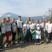 group of students in white t-shirts in front of mountain