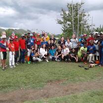 Group of people posing for a photo at an open field.